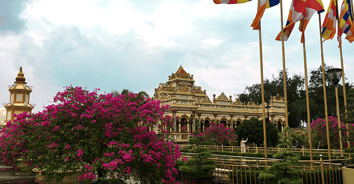 large temple with bright pink flowers in foreground