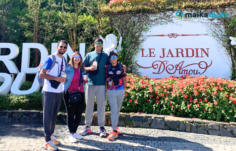 tourists standing at a flower garden 