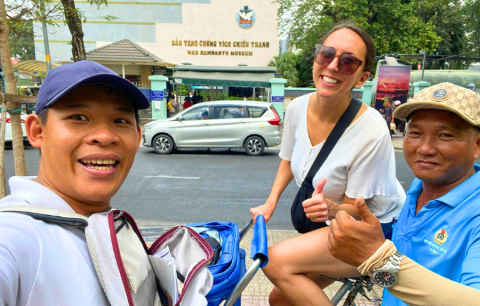 a guide taking a selfie with a tourist and a driver