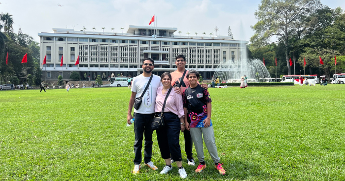 a group of tourists in front of a palace 