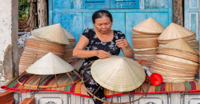 a woman making conical hats