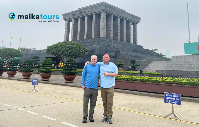 two men standing in front of a mausoleum