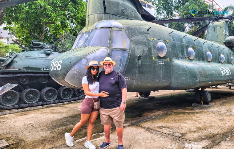 two people standing next to a helicopter