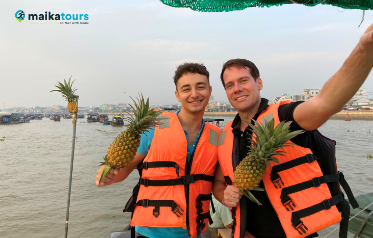 two men taking photos with pineapples
